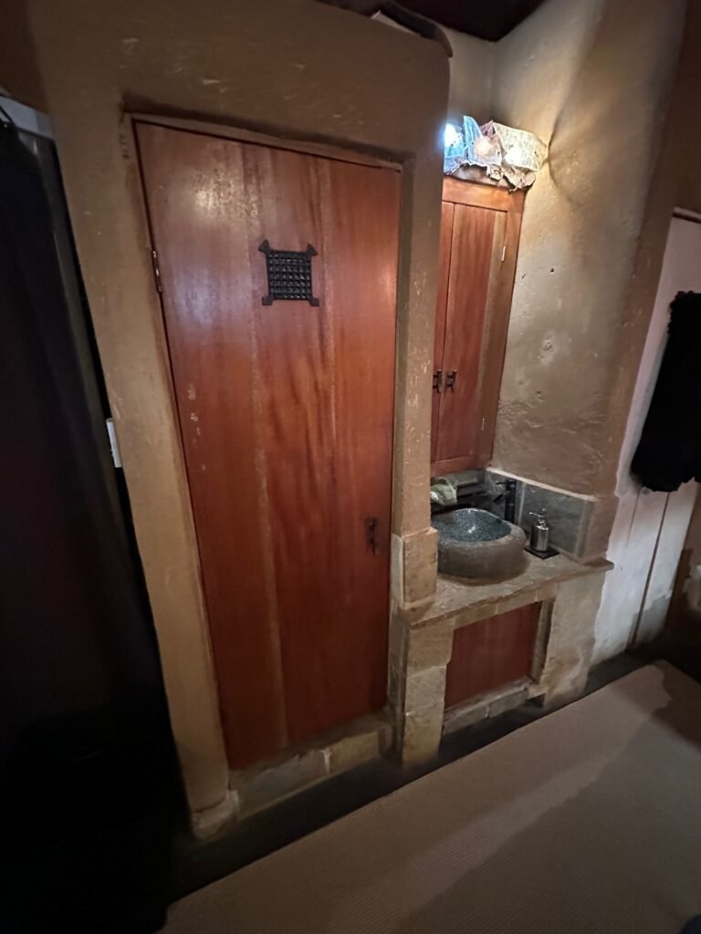 the outhouse-looking room and the stone basin sink